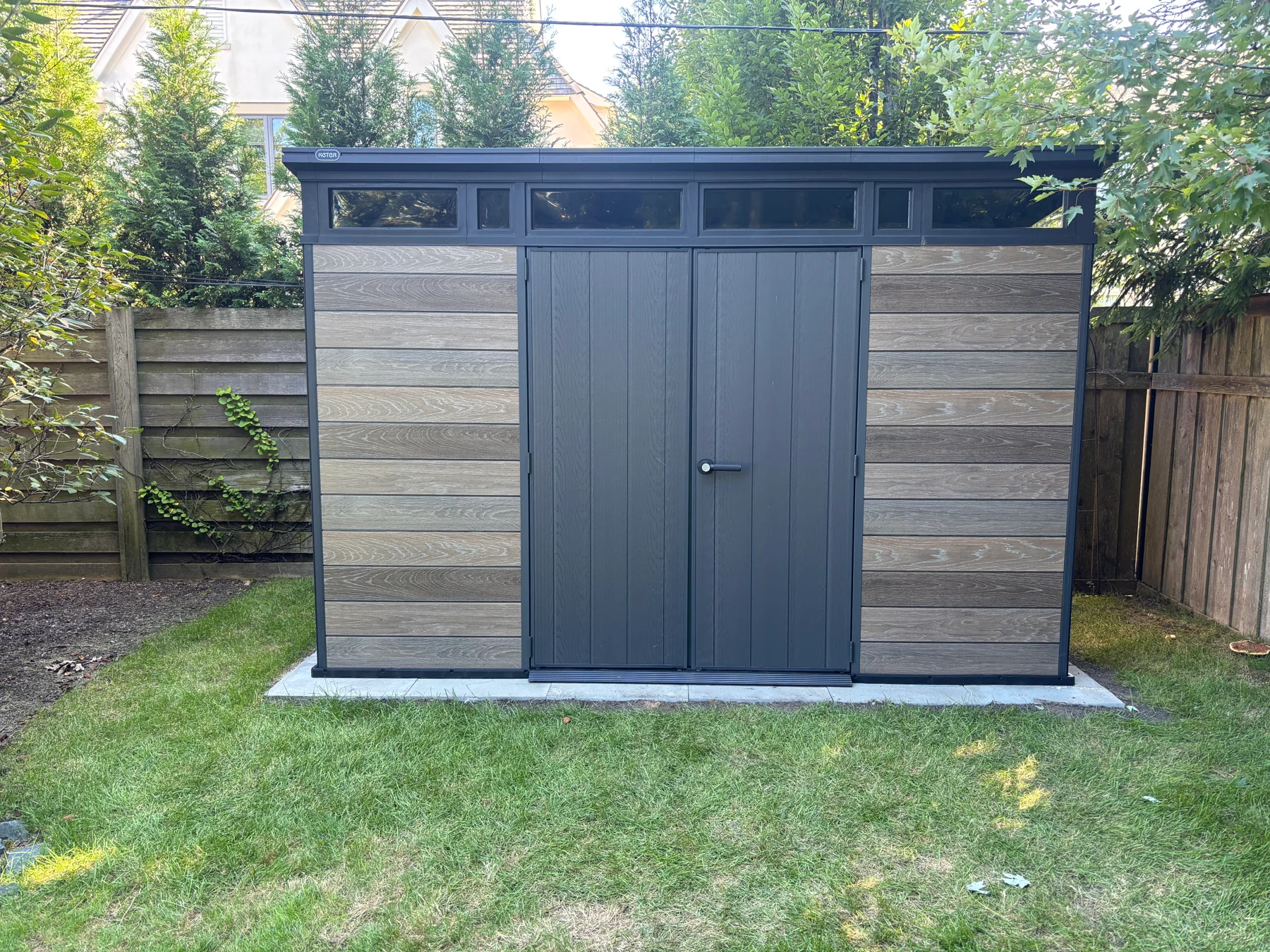 After assembly: the completed shed from the front, showing the double doors and upper window panels.